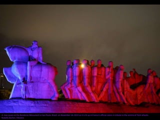 A man poses at the Bandeiras Monument in Sao Paulo, Brazil, on November 14, 2015 as it is lit up in France's official colors in tribute to the victims of Paris attacks.
Rodolfo Burher / Reuters
 
