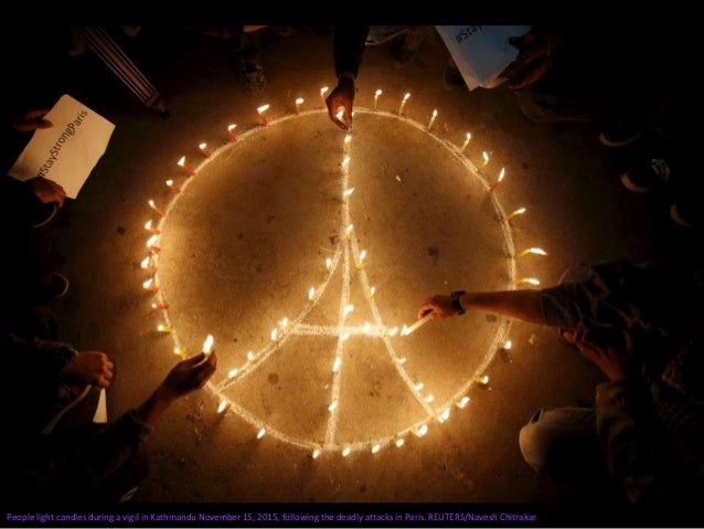 Egyptians light candles as the French and Egyptian flags and France's national colors of blue, white and red are projected...
