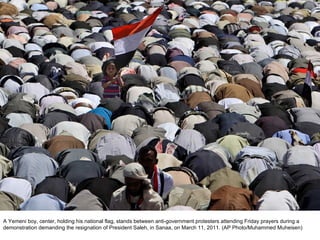 A Yemeni boy, center, holding his national flag, stands between anti-government protesters attending Friday prayers during a demonstration demanding the resignation of President Saleh, in Sanaa, on March 11, 2011. (AP Photo/Muhammed Muheisen)  