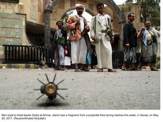 Men loyal to tribal leader Sadiq al-Ahmar, stand near a fragment from a projectile fired during clashes this week, in Sanaa, on May 28, 2011. (Reuters/Khaled Abdullah)  