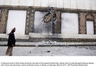 A tribesman loyal to Sheik Sadeq al-Ahmar, the head of the powerful Hashid tribe, stands next to a wall damaged following clashes with Yemeni security forces, next to al-Ahmar's house, in Sanaa, on Saturday, May 28, 2011. (AP Photo/Hani Mohammed  
