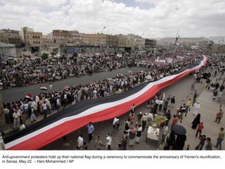 Anti-government protesters hold up their national flag during a ceremony to commemorate the anniversary of Yemen's reunification, in Sanaa, May 22.  - Hani Mohammed / AP  