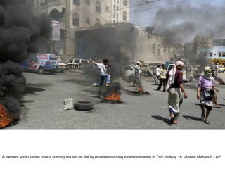 A Yemeni youth jumps over a burning tire set on fire by protesters during a demonstration in Taiz on May 16  -Anees Mahyoub / AP  