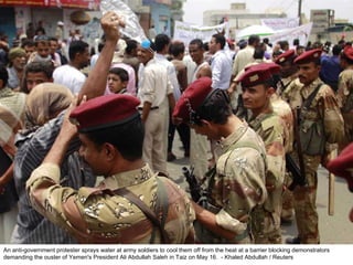 An anti-government protester sprays water at army soldiers to cool them off from the heat at a barrier blocking demonstrators demanding the ouster of Yemen's President Ali Abdullah Saleh in Taiz on May 16.  - Khaled Abdullah / Reuters  