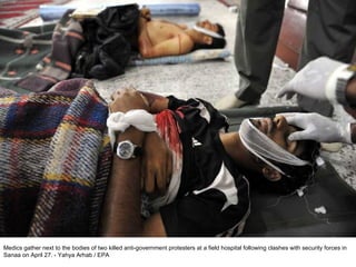 Medics gather next to the bodies of two killed anti-government protesters at a field hospital following clashes with security forces in Sanaa on April 27. - Yahya Arhab / EPA  