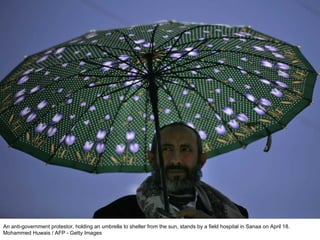An anti-government protestor, holding an umbrella to shelter from the sun, stands by a field hospital in Sanaa on April 18. Mohammed Huwais / AFP - Getty Images  