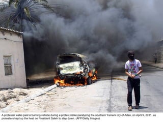 A protester walks past a burning vehicle during a protest strike paralyzing the southern Yemeni city of Aden, on April 9, 2011, as protesters kept up the heat on President Saleh to step down. (AFP/Getty Images)  