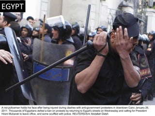 A riot policeman holds his face after being injured during clashes with anti-government protesters in downtown Cairo Janua...