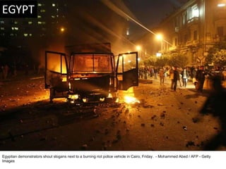 Egyptian demonstrators shout slogans next to a burning riot police vehicle in Cairo, Friday.  - Mohammed Abed / AFP - Gett...