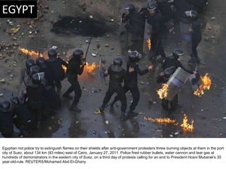 Egyptian riot police try to extinguish flames on their shields after anti-government protesters threw burning objects at t...