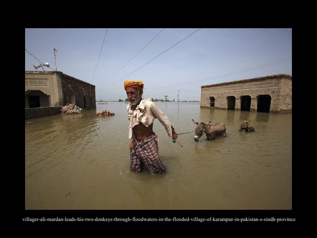 afloodvictimsitswithhisbelongingswhilewaitingtobeevacuated…