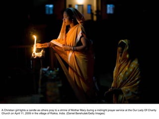 A Christian girl lights a candle as others pray to a shrine of Mother Mary during a midnight prayer service at the Our Lady Of Charity Church on April 11, 2009 in the village of Raikia, India. (Daniel Berehulak/Getty Images)  
