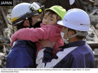 A child is held by rescue workers after being rescued from a building at Kesennuma, northeastern Japan March 12. (Kyodo News/Associated Press)  