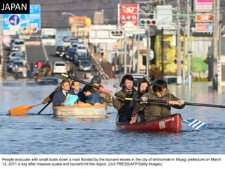 People evacuate with small boats down a road flooded by the tsunami waves in the city of Ishinomaki in Miyagi prefecture on March 12, 2011 a day after massive quake and tsunami hit the region. (JIJI PRESS/AFP/Getty Images)  