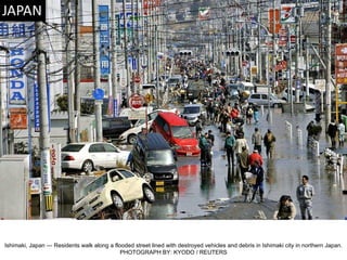 Ishimaki, Japan — Residents walk along a flooded street lined with destroyed vehicles and debris in Ishimaki city in northern Japan. PHOTOGRAPH BY: KYODO / REUTERS 