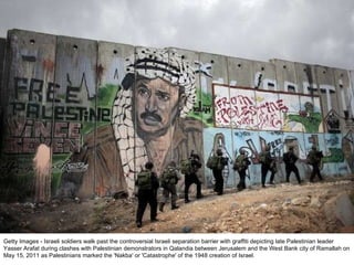 Getty Images - Israeli soldiers walk past the controversial Israeli separation barrier with graffiti depicting late Palestinian leader Yasser Arafat during clashes with Palestinian demonstrators in Qalandia between Jerusalem and the West Bank city of Ramallah on May 15, 2011 as Palestinians marked the 'Nakba' or 'Catastrophe' of the 1948 creation of Israel. 