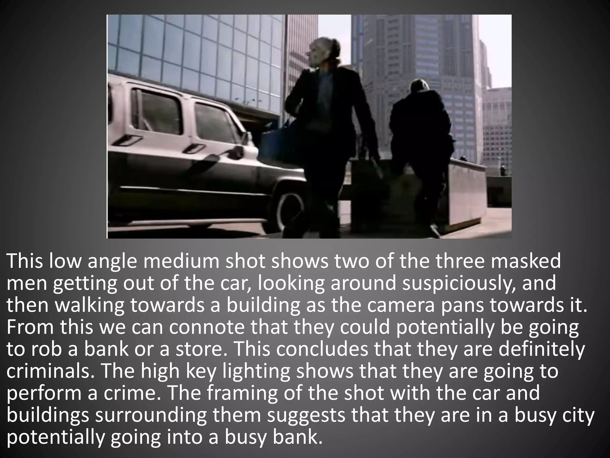 This low angle medium shot shows two of the three masked
men getting out of the car, looking around suspiciously, and
then walking towards a building as the camera pans towards it.
From this we can connote that they could potentially be going
to rob a bank or a store. This concludes that they are definitely
criminals. The high key lighting shows that they are going to
perform a crime. The framing of the shot with the car and
buildings surrounding them suggests that they are in a busy city
potentially going into a busy bank.
 
