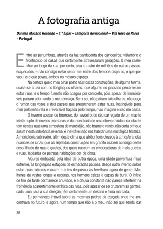 86
A fotografia antiga
Daniela Macário Resende – 1.º lugar – categoria iternacional – Vila Nova de Paiva
- Portugal
E
ntre as penumbras, através da luz pardacenta dos candeeiros, vislumbro o
frontispício de casas que certamente atravessaram gerações. O meu cami-
nhar ao longo da rua, por certo, pisa o rastro de milhões de outros passos,
esquecidos, e não consigo evitar sentir-me entre dois tempos díspares, o que po-
voou, e o que povoa, ambos no mesmo espaço.
Na certeza que o meu olhar posto nas toscas construções, de alguma forma,
quase se cruza com os longínquos olhares, que algures no passado percorreram
estas ruas, e o tempo funesto não apagou por completo, pois apesar de inominá-
veis pairam adornando o meu encalço. Bem sei, não pairam tais olhares, não ouço
o rumor das vozes e dos passos que preencheram estas ruas, inatingíveis para
mim pela linha reta e irreversível traçada pelo tempo, mas imagino e isso me basta.
O inverno apesar de brumoso, do nevoeiro, do céu carregado de um manto
ininterrupto de nuvens plúmbeas, e da monotonia de uma chuva miúda e constante
tem nestas ruas uma atmosfera de mansidão, não brame o vento, não corta o frio, e
assim nesta indolência invernal é inevitável não nos habitar uma nostálgica tristeza.
A monotonia sobrevém, além deste clima que atribui tons cínzeos à atmosfera, das
nuances de cinza, que as repetidas construções em granito exibem ao longo deste
ensarilhado de ruas e guetos, dos quais nascem as embocaduras de mais guetos
e ruas, ladeadas de pétreas habitações cor de cinza.
Algures embalada pela ideia de outra época, uma idade porventura mais
estreme, as longínquas estações de esmeradas paixões, desce outro inverno sobre
estas ruas, séculos voaram, e antes despovoadas fervilham agora de gente. Mu-
lheres de vestes longas e escuras, nos homens calças e capas de burel. O início
de fim de tarde permanece anuviado, e a chuva constante não parece interferir na
fremência aparentemente errática das ruas, pois apesar de se cruzarem as gentes,
cada uma para a sua direção, têm certamente um destino e hora marcada.
Eu permaneço imóvel sobre as mesmas pedras da calçada onde me en-
contrava no futuro, e agora num tempo que não é o meu, não sei que senda dar
 