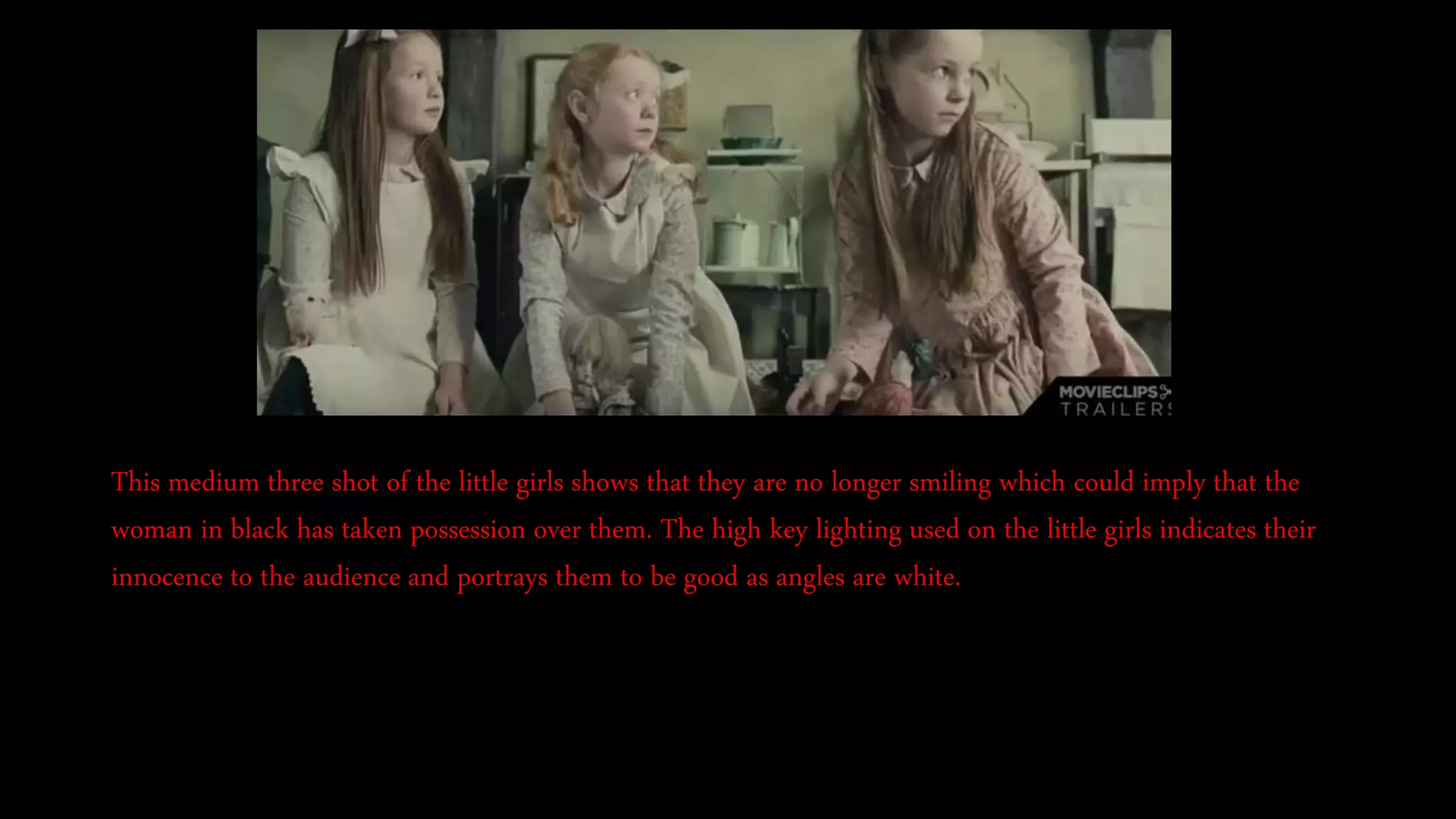 This medium three shot of the little girls shows that they are no longer smiling which could imply that the
woman in black has taken possession over them. The high key lighting used on the little girls indicates their
innocence to the audience and portrays them to be good as angles are white.
 