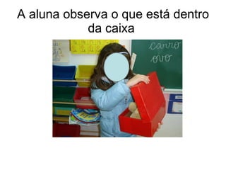A aluna observa o que está dentro da caixa  