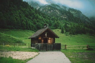 Wooden house surrounded by grass.