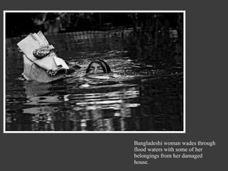 Bangladeshi woman wades through flood waters with some of her belongings from her damaged house. 