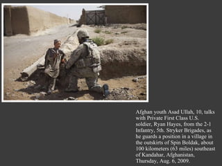 Afghan youth Asad Ullah, 10, talks with Private First Class U.S. soldier, Ryan Hayes, from the 2-1 Infantry, 5th. Stryker Brigades, as he guards a position in a village in the outskirts of Spin Boldak, about 100 kilometers (63 miles) southeast of Kandahar, Afghanistan, Thursday, Aug. 6, 2009. 