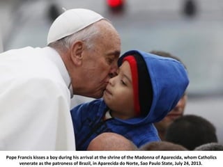 Pope Francis kisses a boy during his arrival at the shrine of the Madonna of Aparecida, whom Catholics
venerate as the pat...
