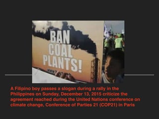 A Filipino boy passes a slogan during a rally in the
Philippines on Sunday, December 13, 2015 criticize the
agreement reached during the United Nations conference on
climate change, Conference of Parties 21 (COP21) in Paris
 
