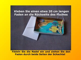 Kleben Sie einen etwa 20 cm langen Faden an die Rückseite des Fisches   Fädeln Sie die Nadel ein und ziehen Sie den Faden durch beide Seiten der Schachtel 