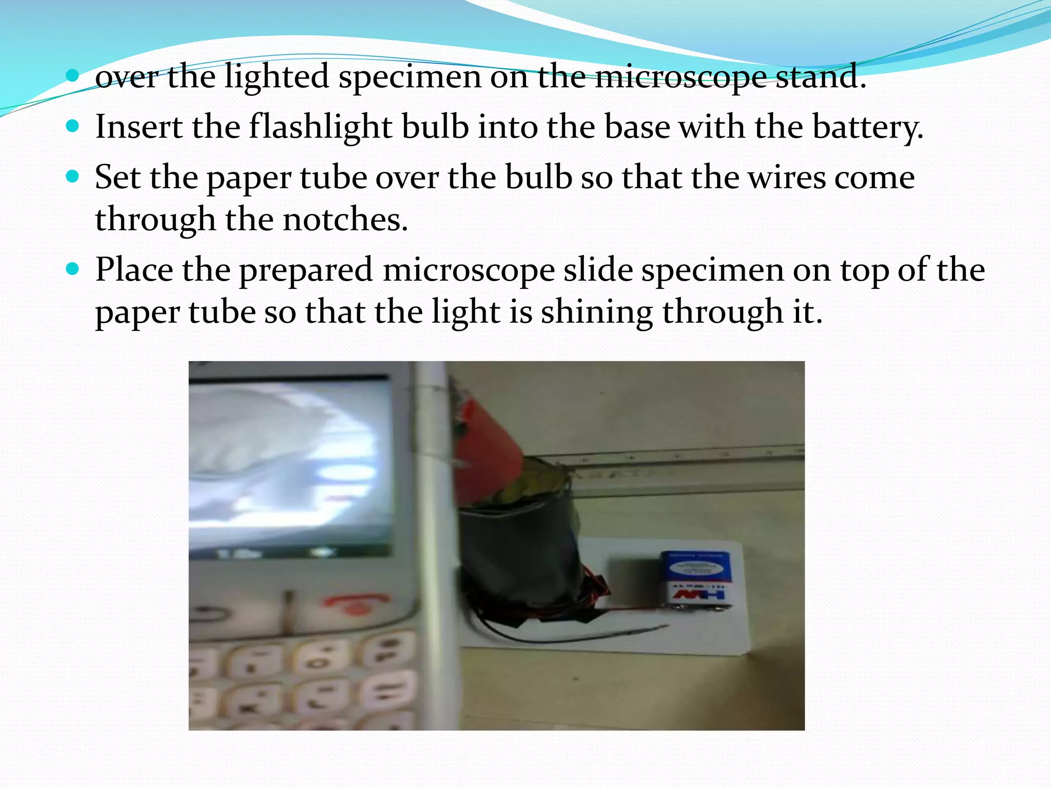  over the lighted specimen on the microscope stand.
 Insert the flashlight bulb into the base with the battery.
 Set the paper tube over the bulb so that the wires come

through the notches.
 Place the prepared microscope slide specimen on top of the
paper tube so that the light is shining through it.

 