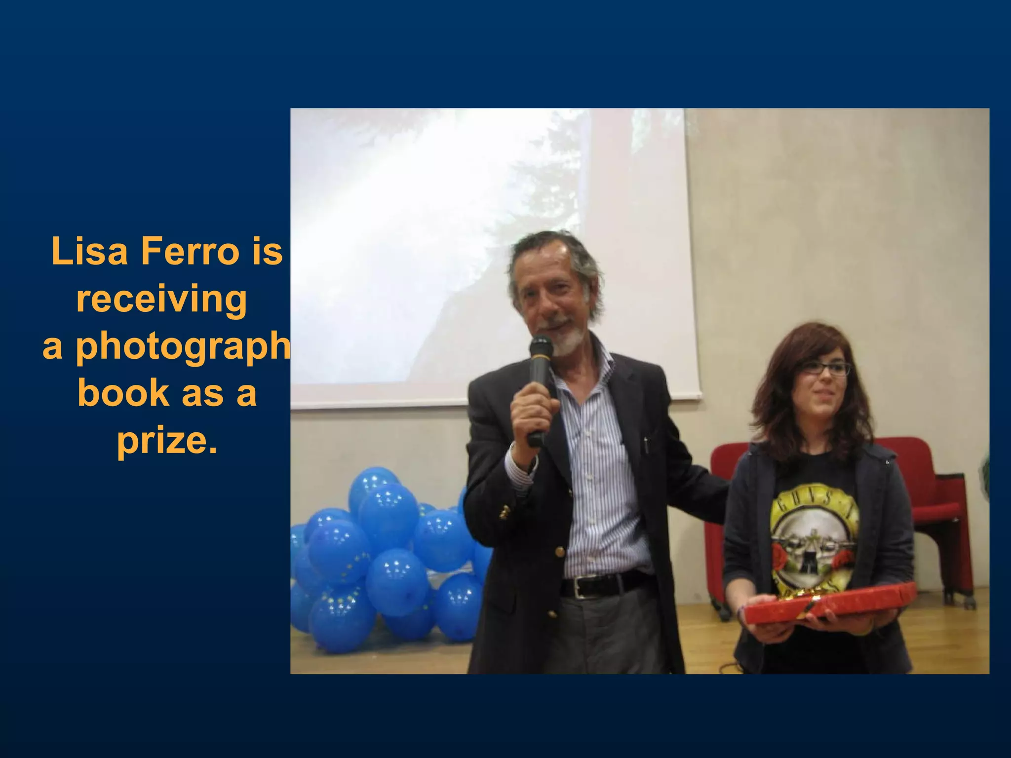 Lisa Ferro is receiving  a photograph book as a prize. 