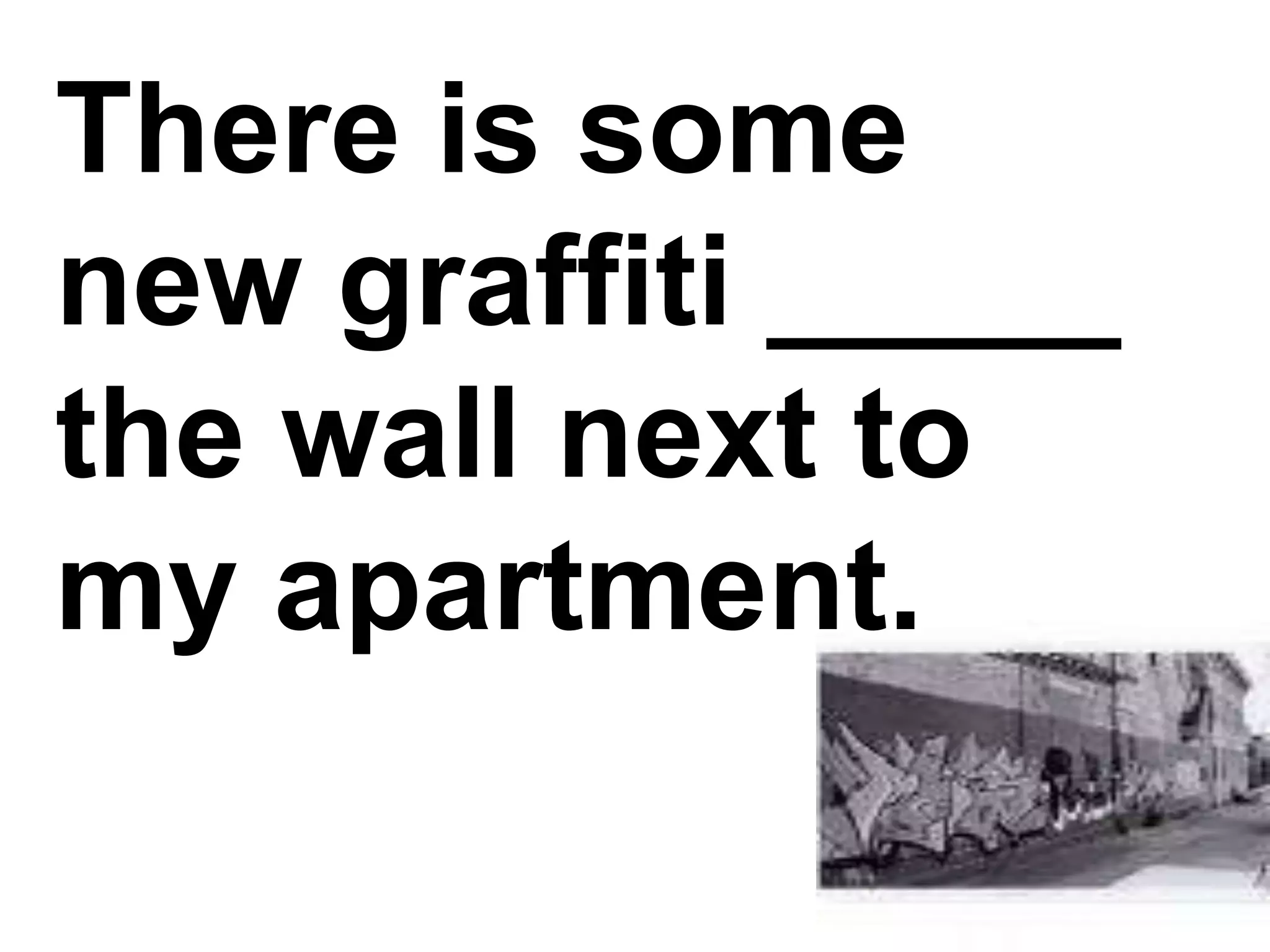 There is some new graffiti _____ the wall next to my apartment.