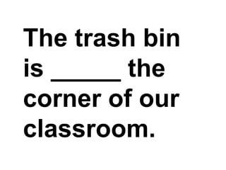 The trash bin is _____ the corner of our classroom.