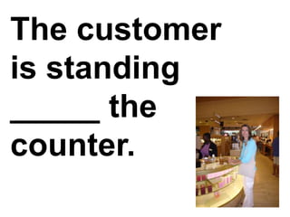The customer is standing _____ the counter.