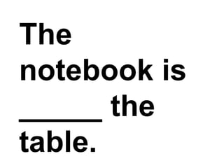 The notebook is _____ the table.