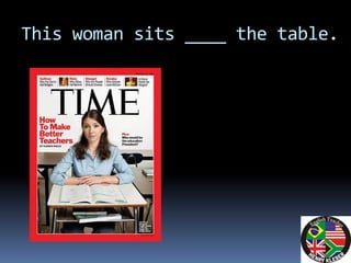 This woman sits ____ the table.
 