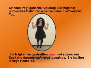OrihanaträgtgotischeKleidung. SieträgteinschwarzesBallettröckchenmiteinemschwarzenTop.SieträgteinengestreiftenrosaundschwarzenSockunddarunterschwarzeLeggings.  SiehatihrelockigeHaare los.