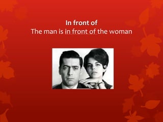 In front of 
The man is in front of the woman 
 