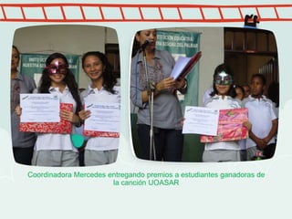 Coordinadora Mercedes entregando premios a estudiantes ganadoras de
la canción UOASAR
 