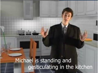 Michael is standing and  gesticulating in the kitchen 
