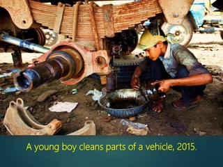 A young boy cleans parts of a vehicle, 2015.
 