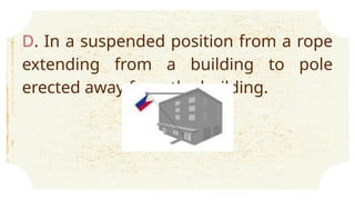 D. In a suspended position from a rope
extending from a building to pole
erected away from the building.
 