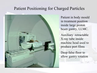 Patient Positioning for Charged Particles Patient in body mould in treatment position inside large proton beam gantry, LLMC.  Auxiliary  retractable X-ray tube inside machine head used to produce port films Deep false floor to allow gantry rotation 