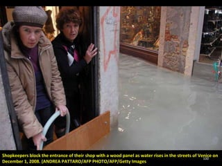 Shopkeepers block the entrance of their shop with a wood panel as water rises in the streets of Venice on December 1, 2008. (ANDREA PATTARO/AFP PHOTO/AFP/Getty Images 