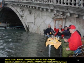 17Men share a drink on a flooded plaza near the Rialto bridge on  December 1, 2008 in Venice. (ANDREA PATTARO/AFP PHOTO/AFP/Getty Images 