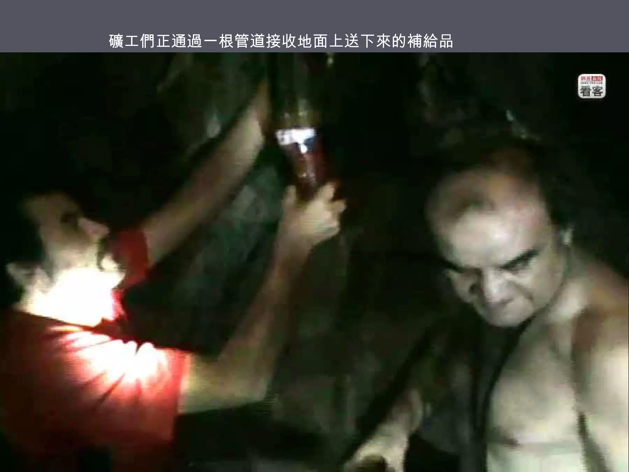 礦工們正通過一根管道接收地面上送下來的補給品

 