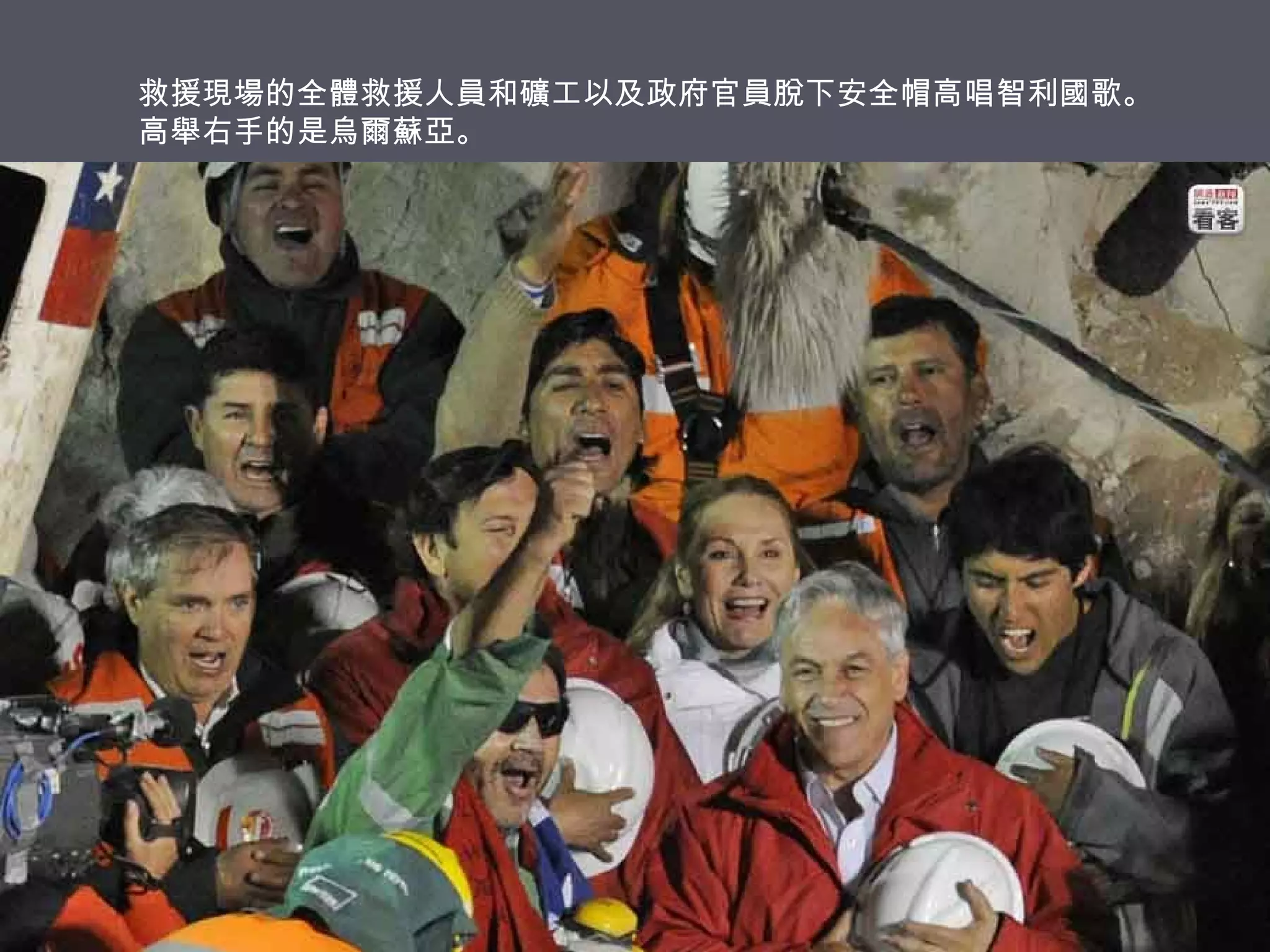 救援現場的全體救援人員和礦工以及政府官員脫下安全帽高唱智利國歌。
高舉右手的是烏爾蘇亞。

 