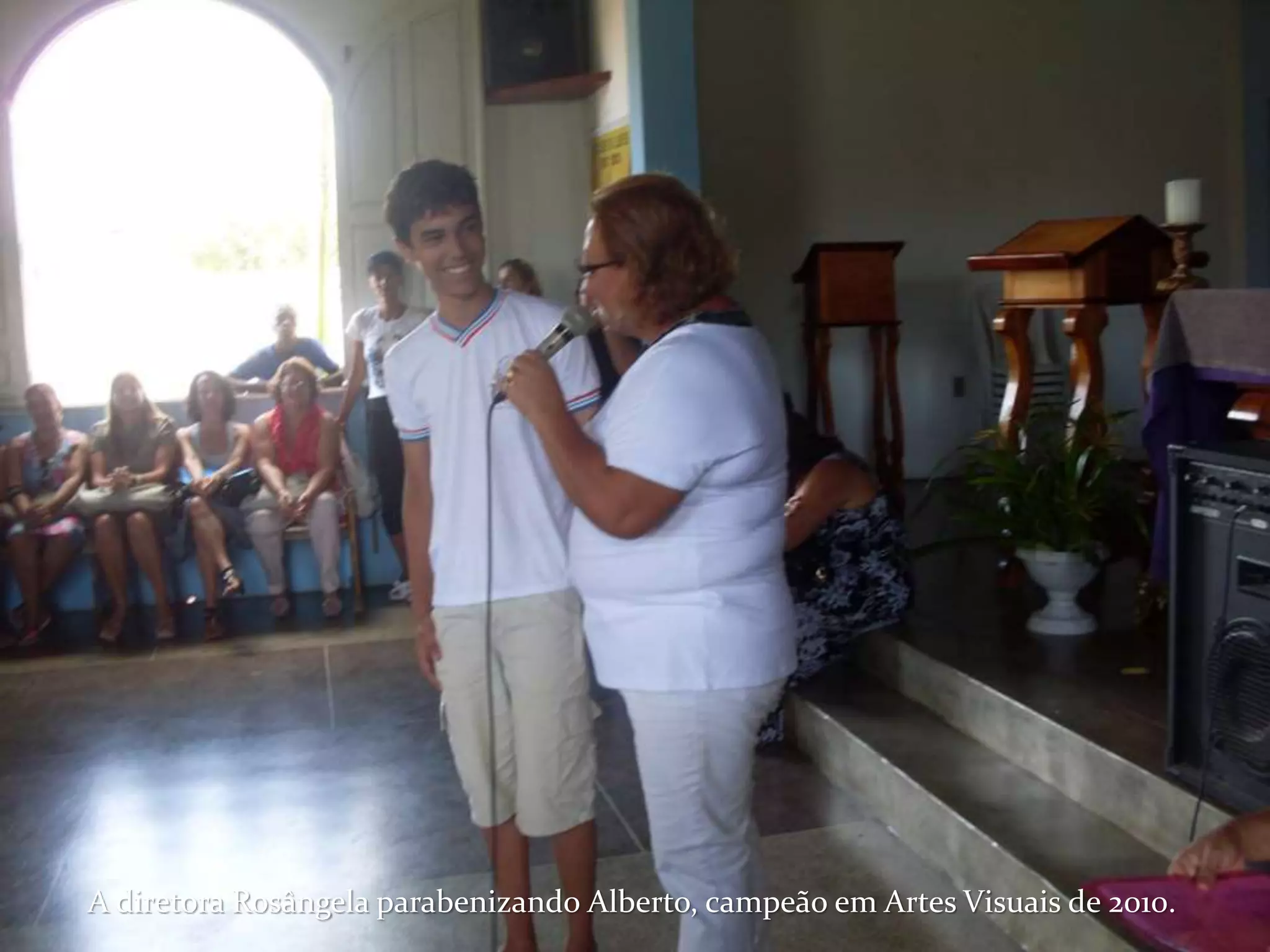 A diretora Rosângela parabenizando Alberto, campeão em Artes Visuais de 2010.