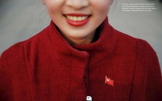 A hostess wears a pin of China's Communist
Party flag ahead of the closing ceremony of
National People's Congress at the G...